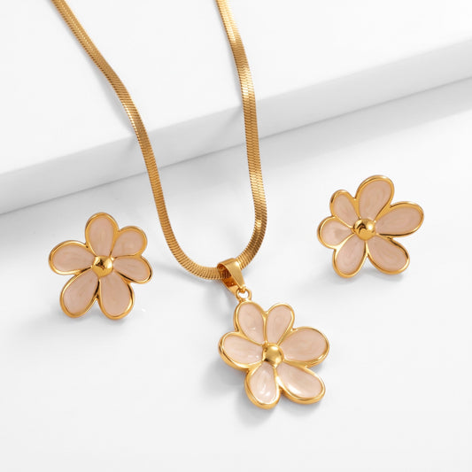Aramat Jewels goudkleurige RVS sieradenset met bloemhanger en bijpassende oorstekers met zachtroze emaille details.