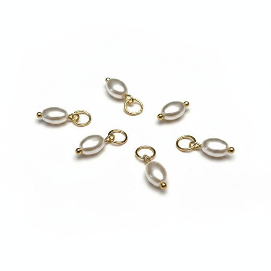 Aramat Jewels oval white synthetic pearl charms with gold-tone metal loops on a white background.