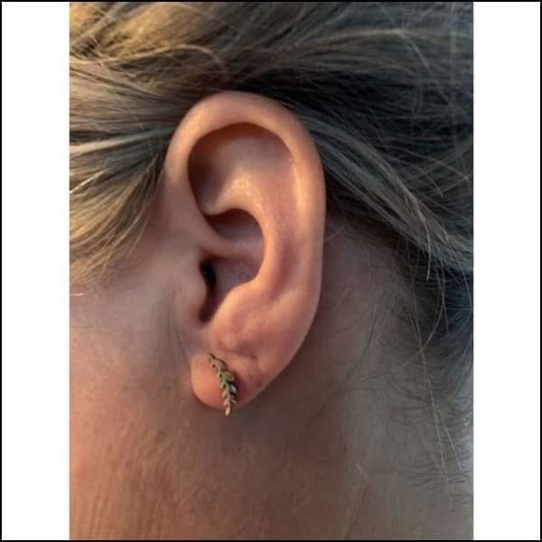 Gouden Bijoorbel Op Een Vrouwenoorgel Met Het Product ’oorbellen Zweerknopjes Blaadje’