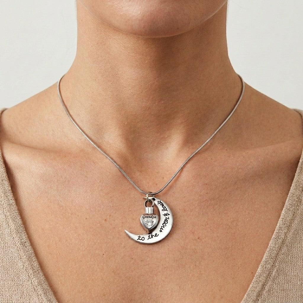 Aramat Jewels zilverkleurige ashanger met maan en hartje, met de tekst 'Grandpa to the moon and back' en een zirkonia.