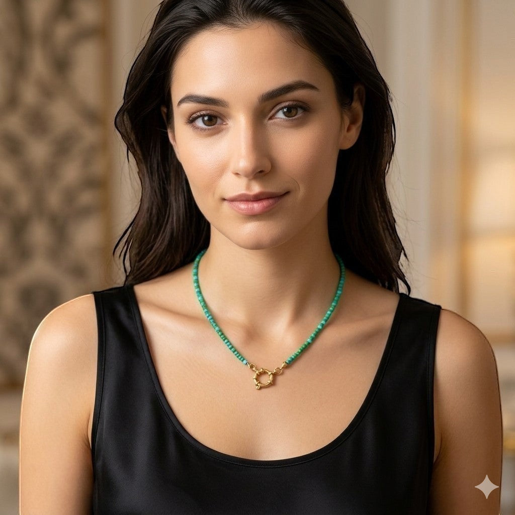 Aramat Jewels beaded necklace with blue and green rocailles and a gold clasp, worn by a model.