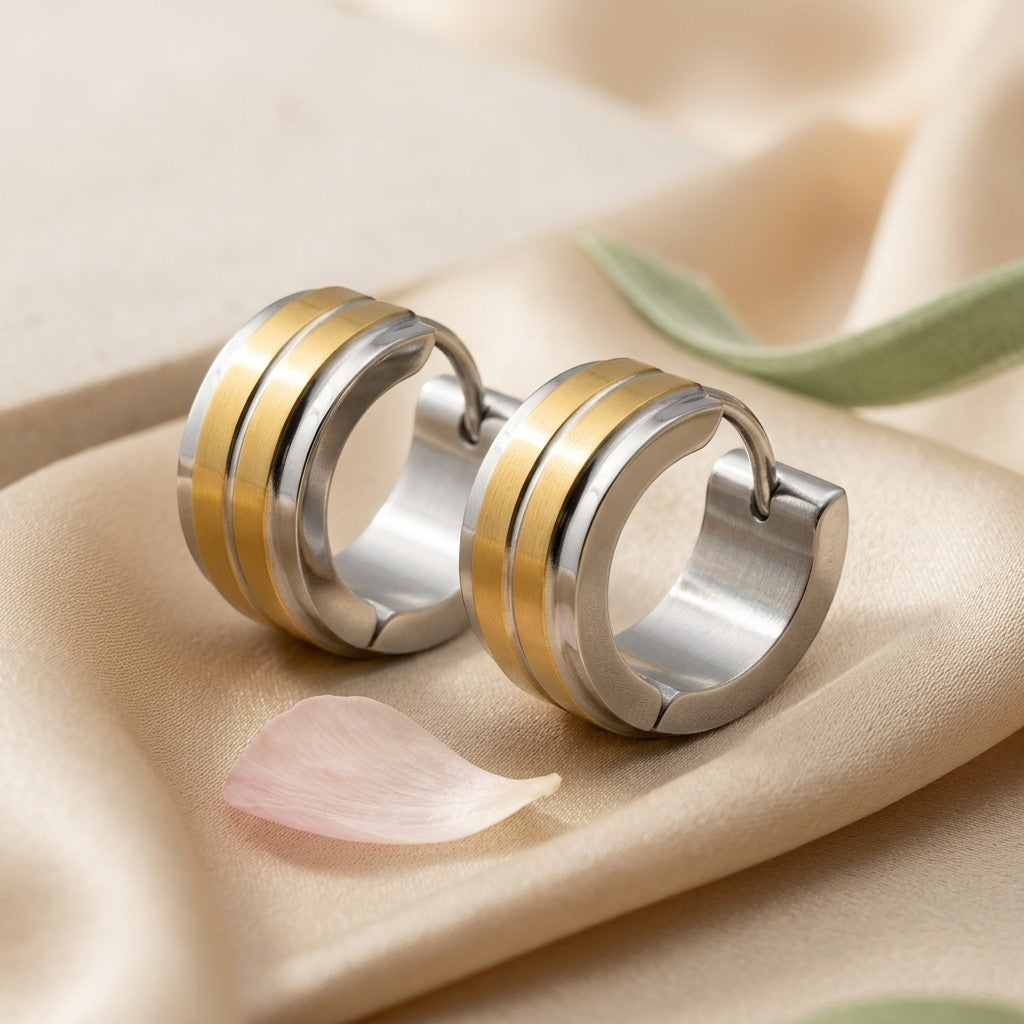 Aramat Jewels stainless steel huggie hoop earrings with a bicolor design featuring two gold-colored stripes.