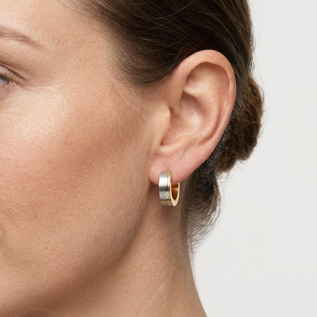 Aramat Jewels bicolor hoop earrings in matte silver and gold, 13mm, worn by a model.