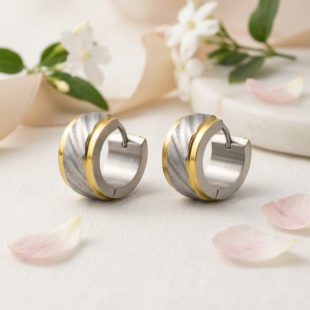 Aramat Jewels huggie hoop earrings in bicolor gold and silver stainless steel with a textured, diamond-cut design.