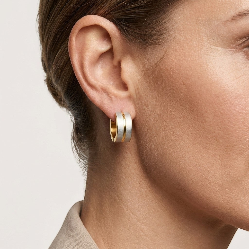 Aramat Jewels matte bicolor stainless steel hoop earrings, 13x7mm, featuring a gold-tone inner band and a matte silver-tone outer band.
