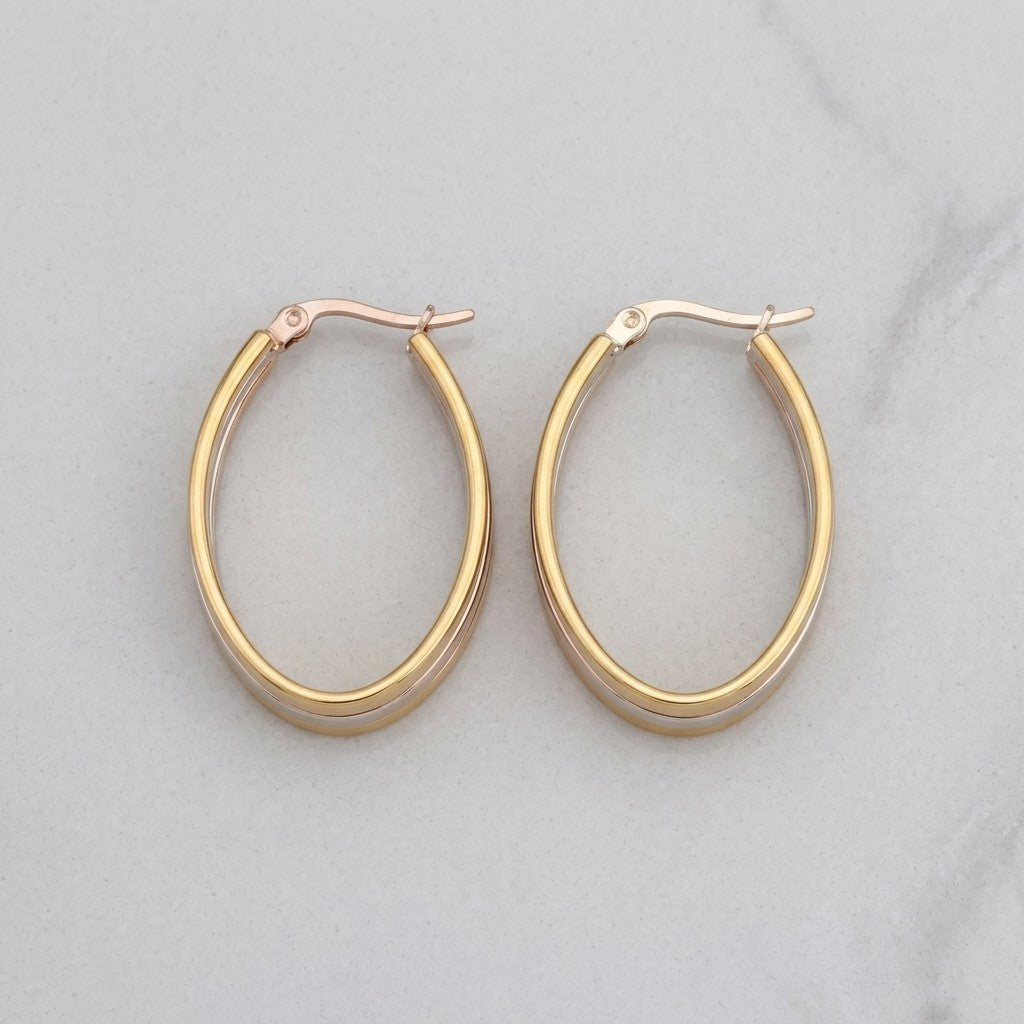 Aramat Jewels oval hoop earrings, 35x9mm, with a bicolor gold and silver finish. Stainless steel construction with a hinge closure.