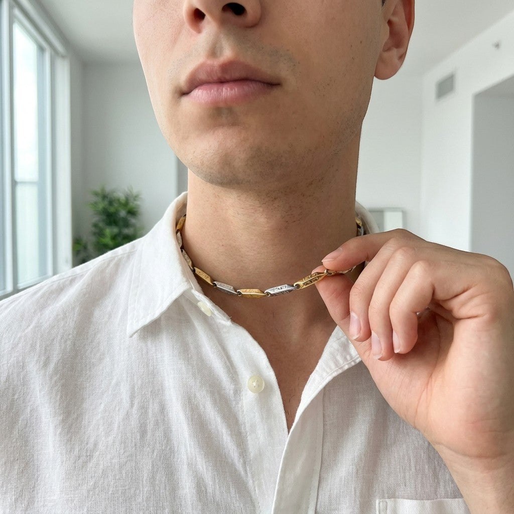 Aramat Jewels bicolor stalen bamboo ketting met Grieks motief gedragen door een man in een wit overhemd.