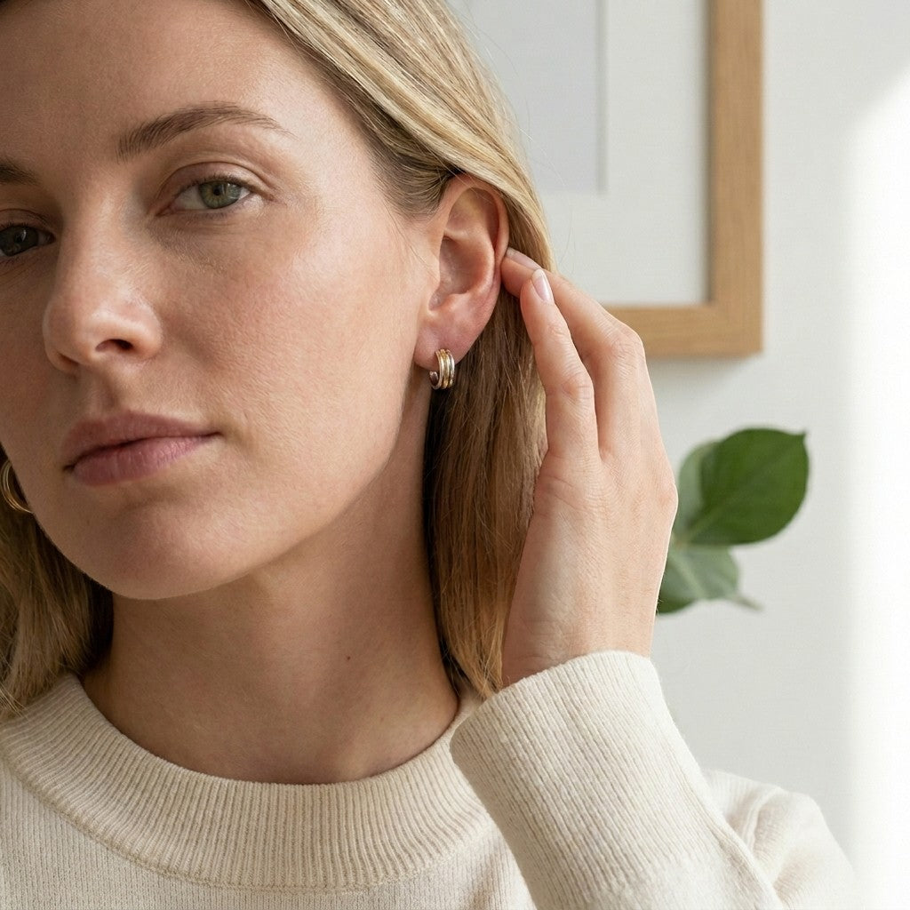 Aramat Jewels bicolor gold and silver striped hoop earrings (13mm) worn by a blonde woman.
