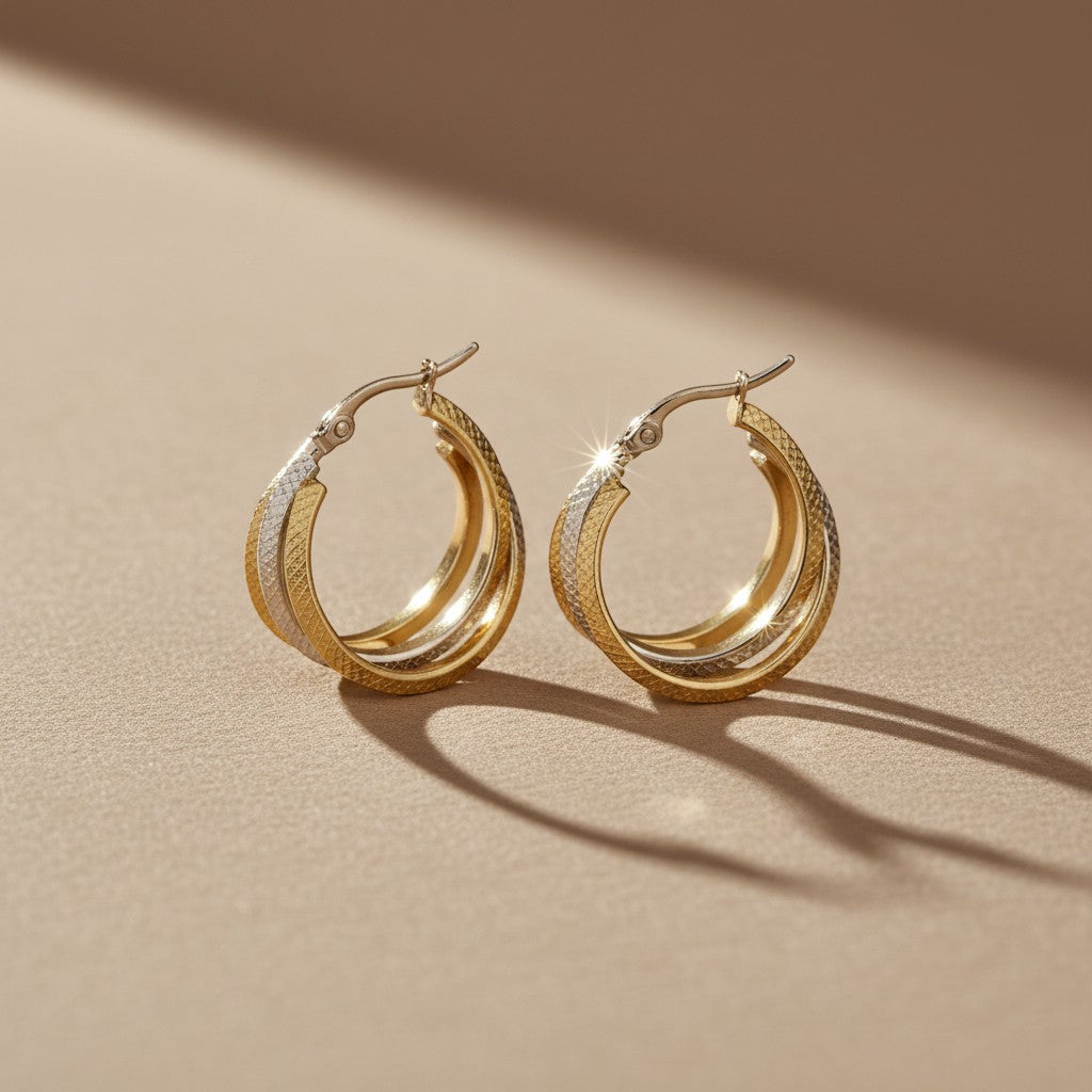 Aramat Jewels bicolor triple hoop earrings with a diamond-cut pattern in gold and silver stainless steel, 35mm diameter.