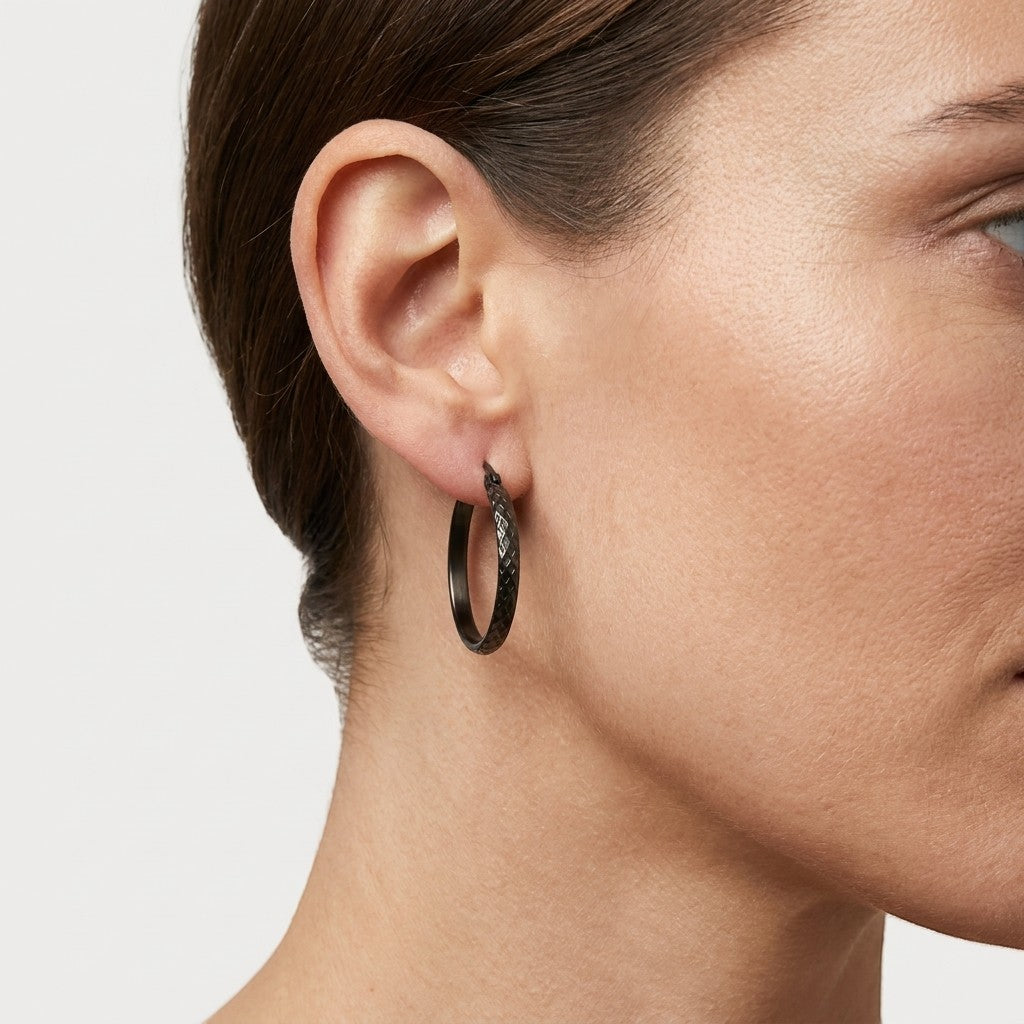 Aramat Jewels black stainless steel hoop earrings with a 30mm diameter and a textured diamond pattern.