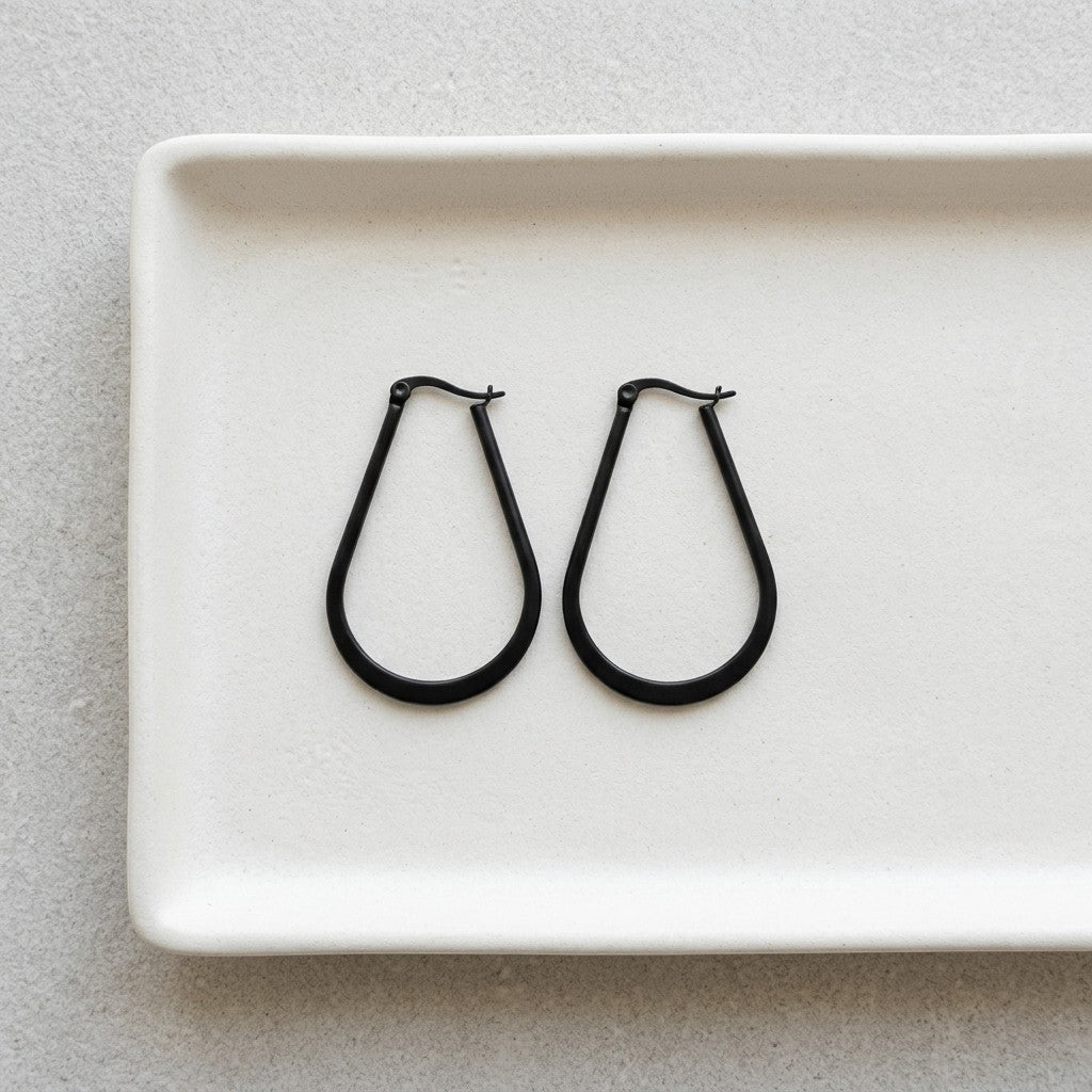 Aramat Jewels black oval hoop earrings made of steel with a shiny finish.