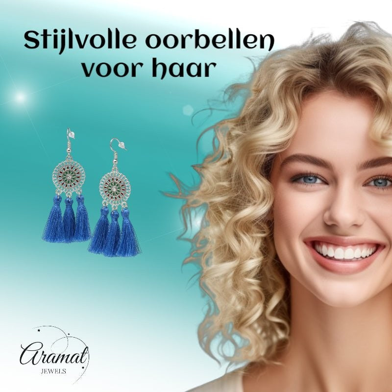 Aramat Jewels blue boho dangle earrings with three tassels and stainless steel accents worn by a smiling woman.