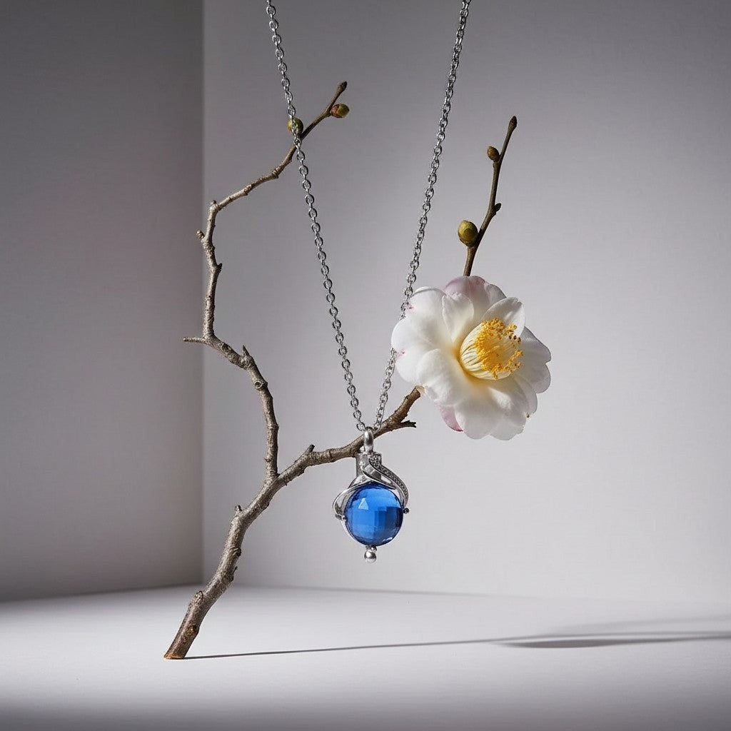 Aramat Jewels silver-colored stainless steel teardrop ash pendant with blue zirconia, 31x18mm, for ashes or hair.