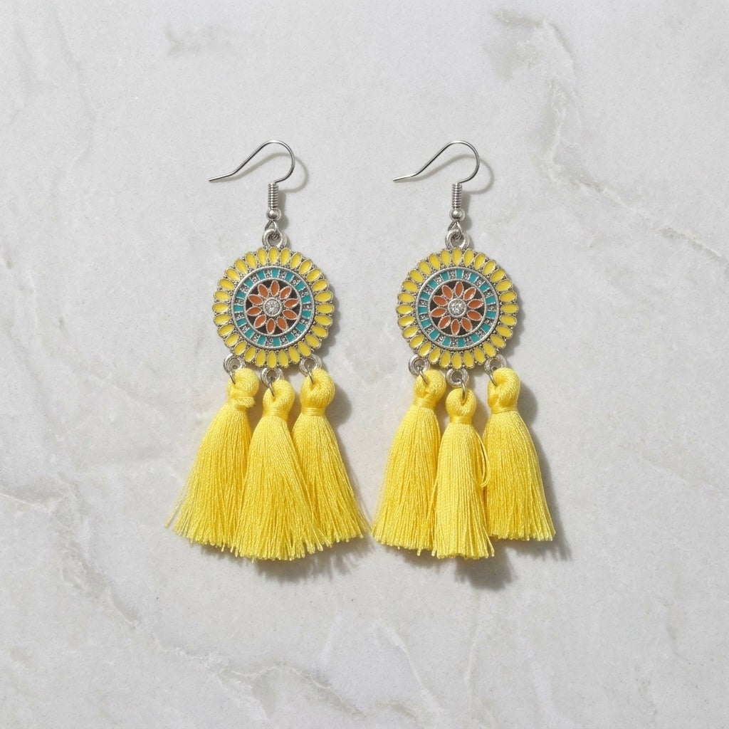 Aramat Jewels boho oorhangers met gele kwastjes, emaille details en roestvrij staal voor een zomerse festival look.