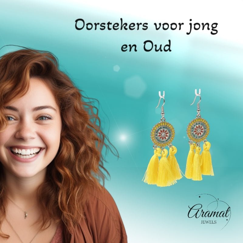 Lachende vrouw met Aramat Jewels boho oorhangers met gele kwastjes, RVS en emaille details voor een zomerse look.