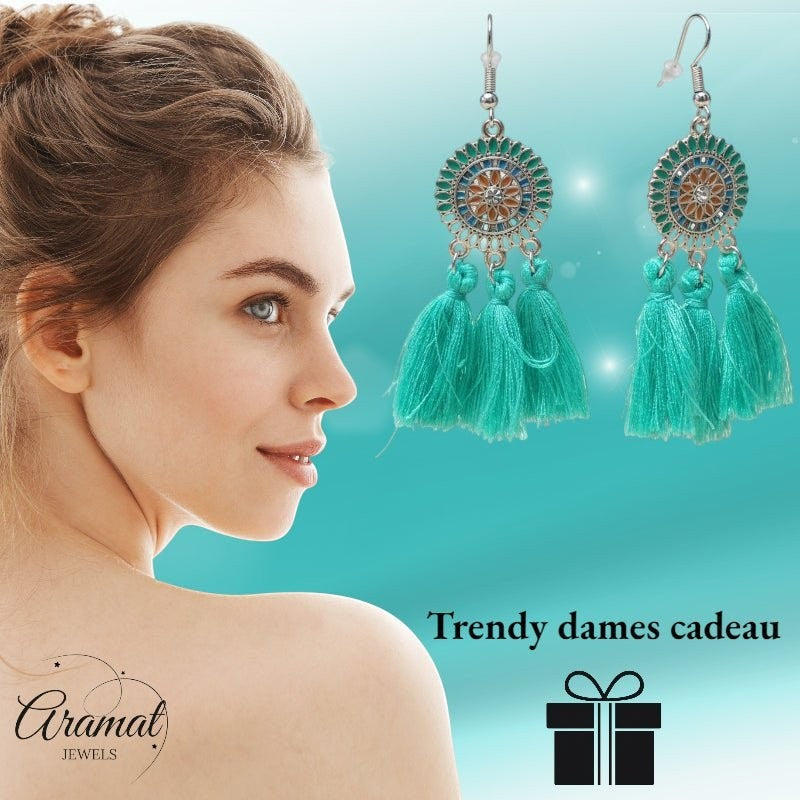 Aramat Jewels boho oorhangers met mintgroene kwastjes en RVS emaille details gedragen door een vrouw.