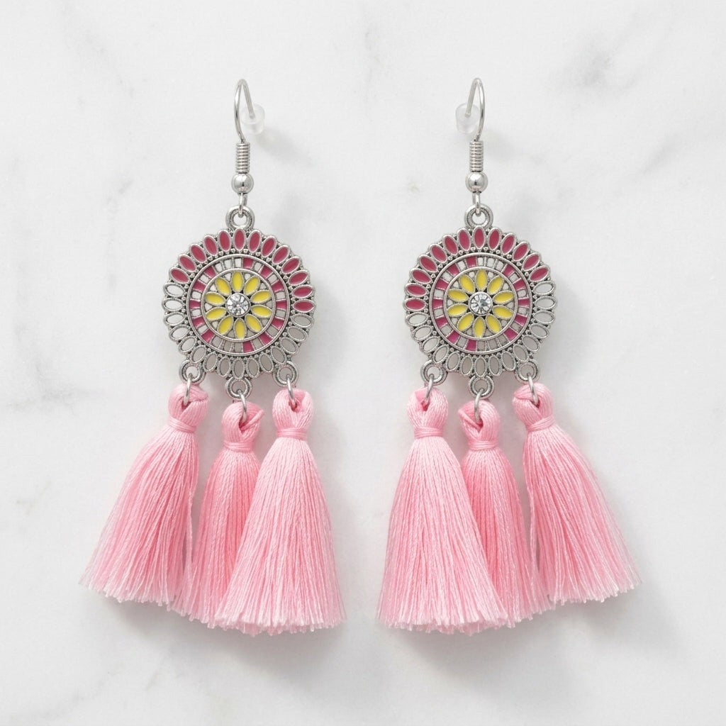Aramat Jewels boho oorhangers met licht roze kwastjes, RVS cirkel met roze en gele emaille details en strass steen.