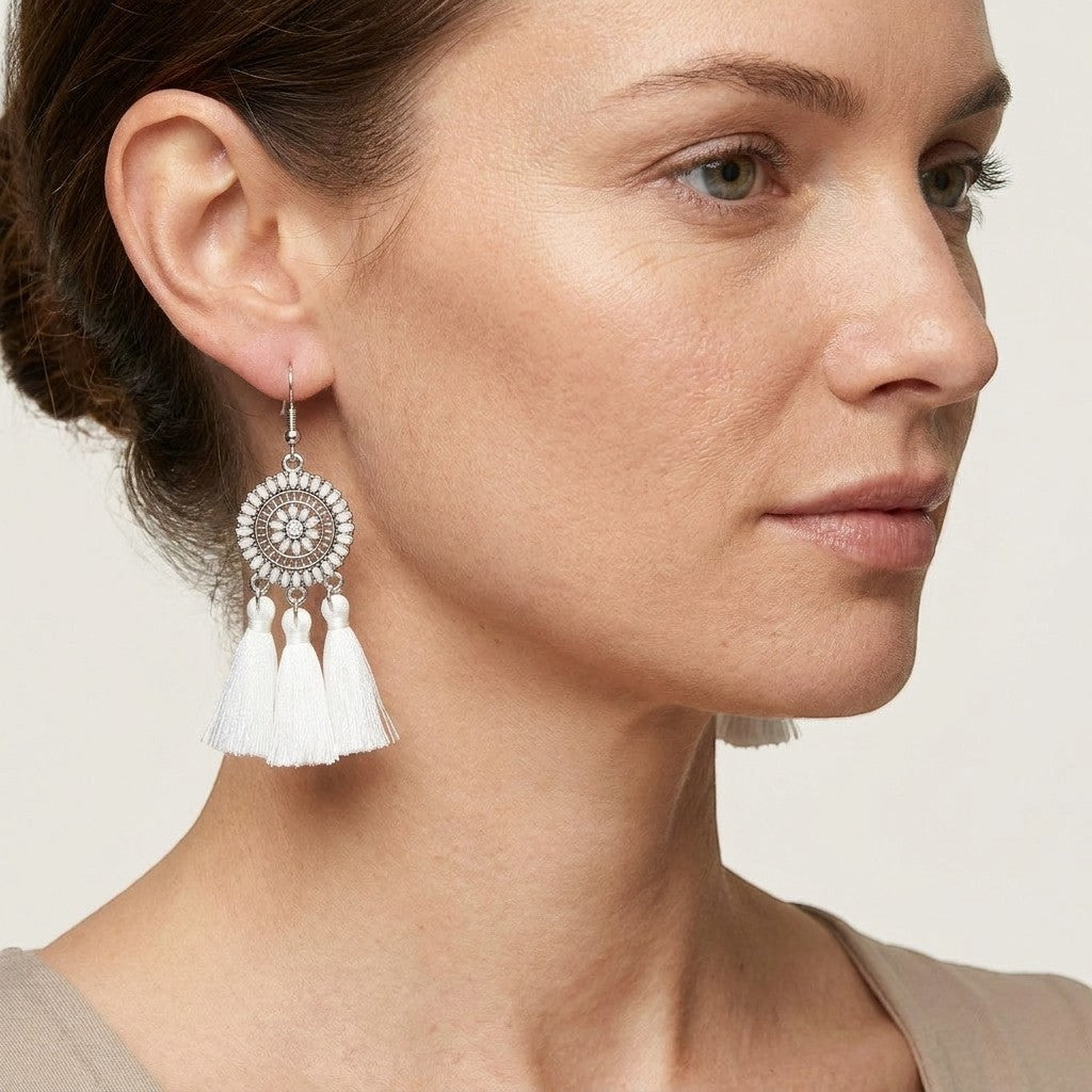 Aramat Jewels boho oorhangers met witte kwastjes en zilverkleurig metaal. 75mm lang.