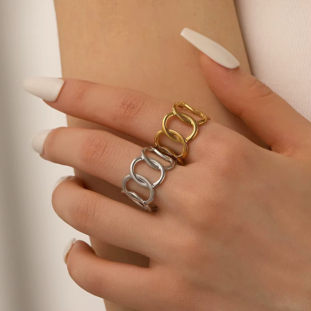 Aramat Jewels brede verstelbare ring van RVS met in elkaar grijpende ovale schakels in goud- en zilverkleur.