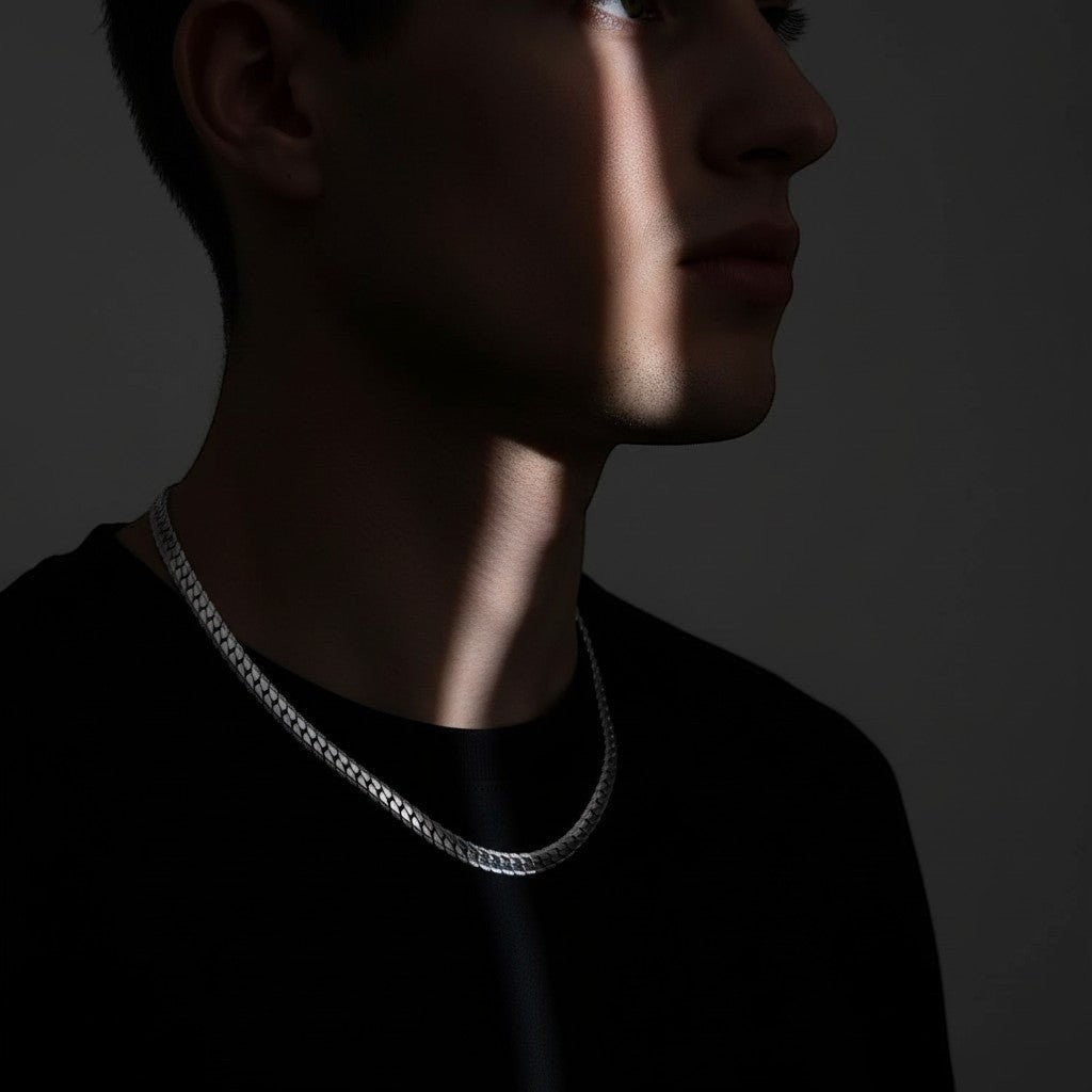Aramat Jewels chunky 8mm zilverkleurige gourmet ketting van RVS gedragen door een man in een stoere, donkere setting.