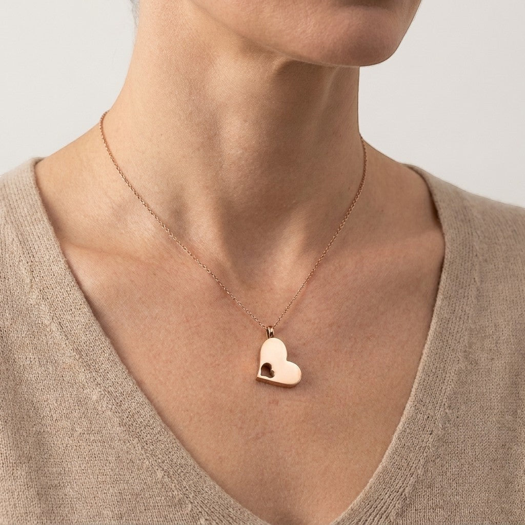 Aramat Jewels stalen rosékleurige crematiehanger in hartvorm met een kleiner hartje uitgesneden. Gedenksieraad zonder ketting.