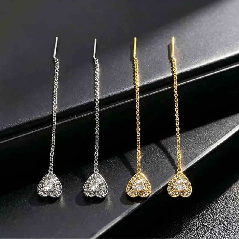 Aramat Jewels doortrek oorbellen van RVS met zirkonia hartjes in zilverkleur en goudkleur, 7 cm lang.