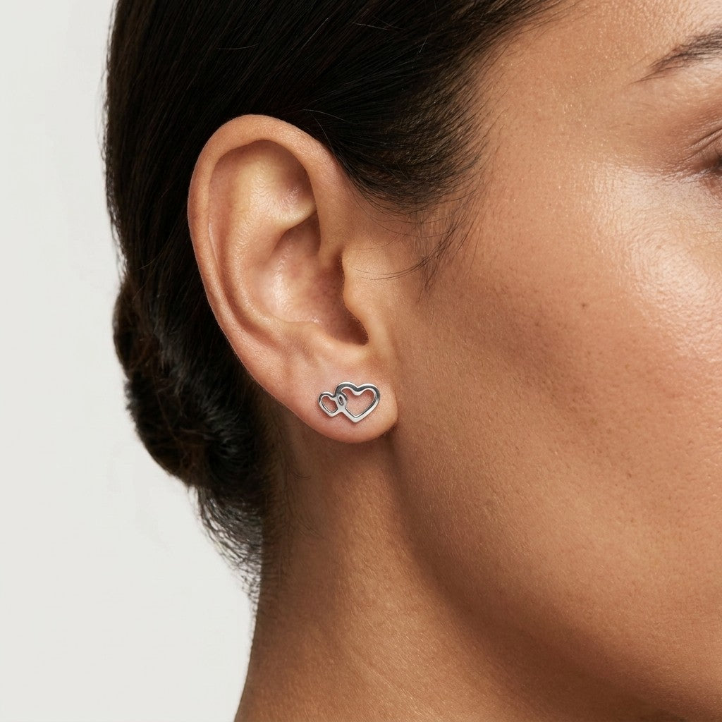 Aramat Jewels zilverkleurige dubbele hartjes oorstekers van RVS, 12x8mm, romantisch design.