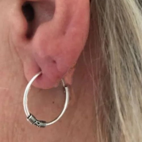 Aramat Jewels 18mm geoxideerde Bali oorringen van 925 sterling zilver met een boho festival design in een oor.