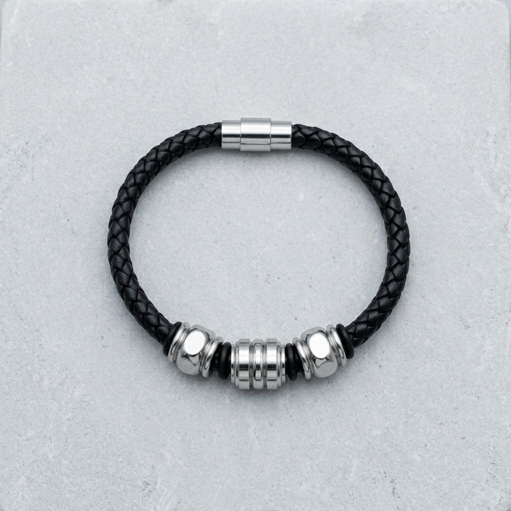 Aramat Jewels gevlochten zwarte leren herenarmband met drie zilverkleurige edelstalen kralen en magnetische sluiting.