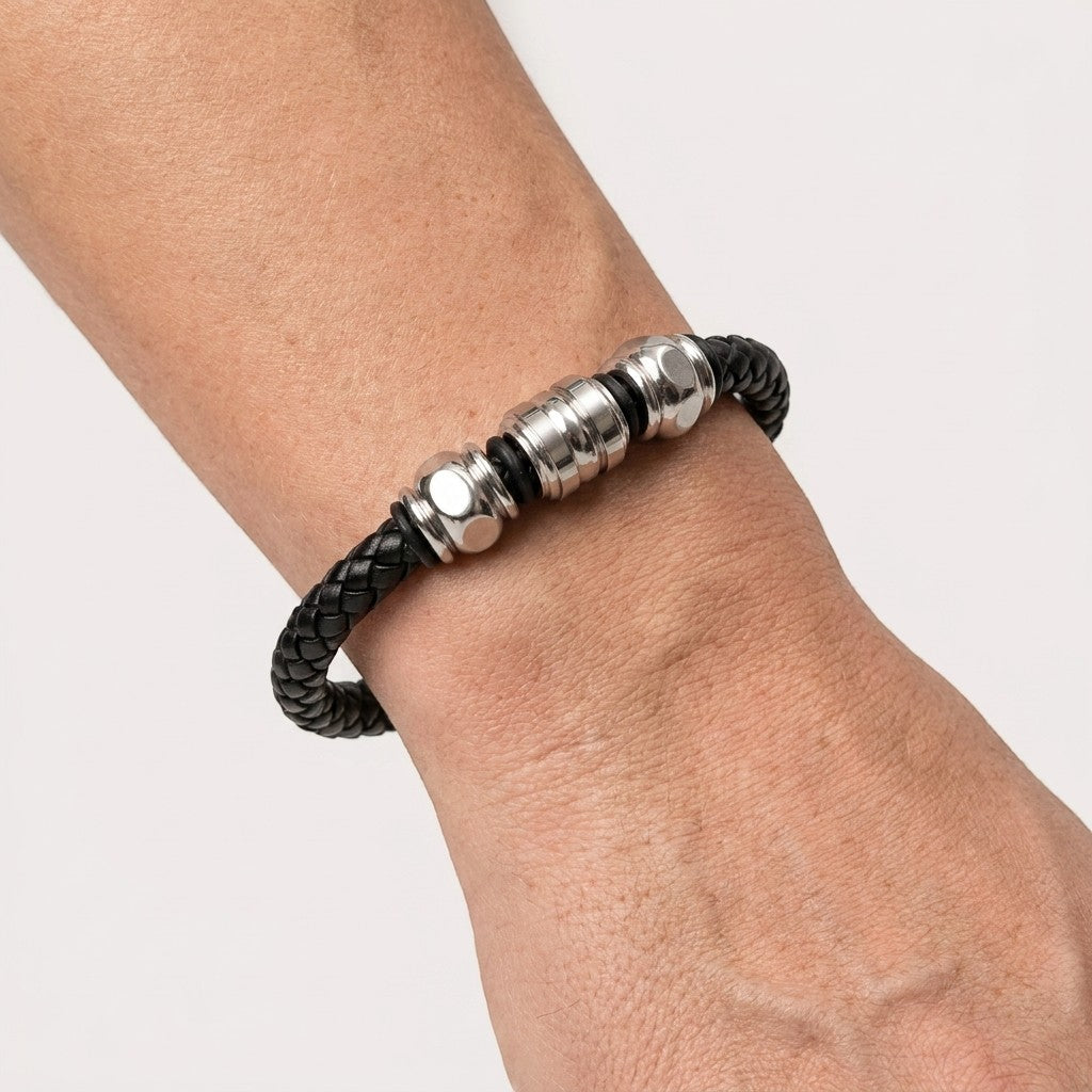 Aramat Jewels gevlochten zwarte leren herenarmband met drie zilverkleurige edelstalen kralen om de pols.