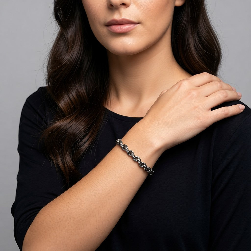 Aramat Jewels zilverkleurige gevlochten stalen armband van 7 mm breed gedragen om de pols van een model.