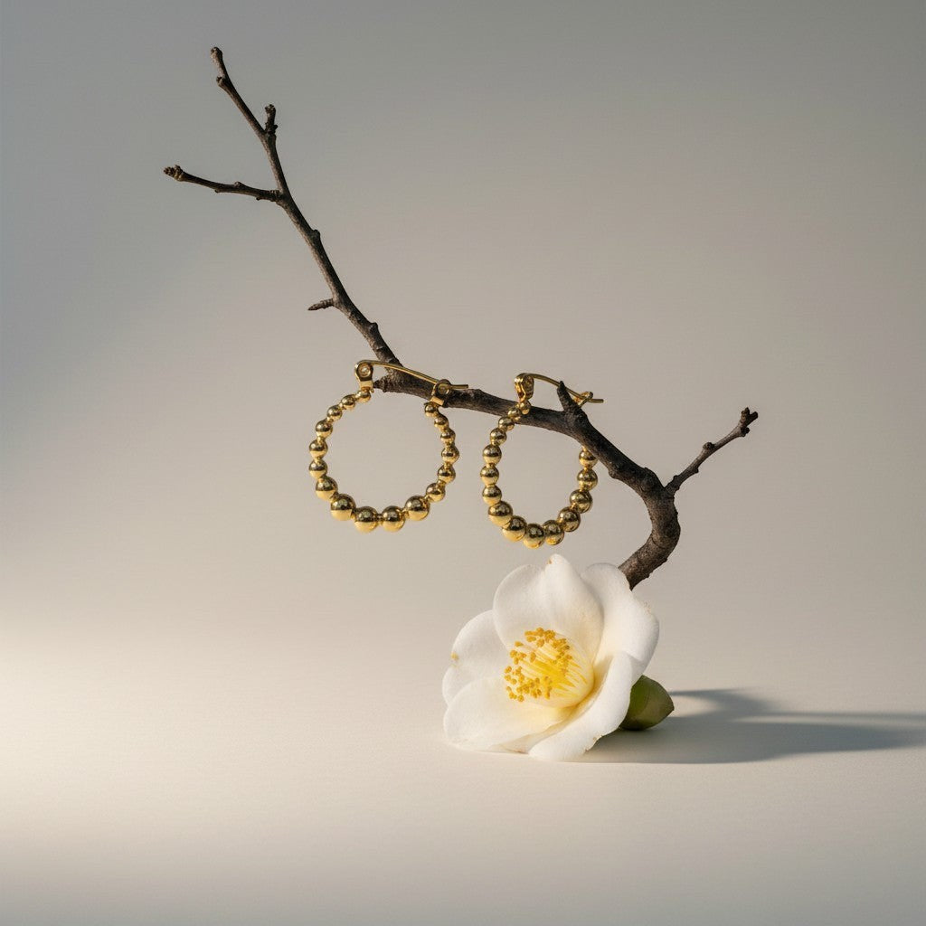Aramat Jewels gold-tone stainless steel hoop earrings with a beaded design, 18mm diameter.