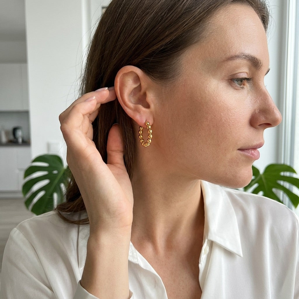 Aramat Jewels gold-tone stainless steel hoop earrings with a beaded chain design, 18mm diameter.