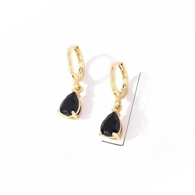 Aramat Jewels gold-tone stainless steel huggie hoop earrings with dangling black teardrop zirconia stones.