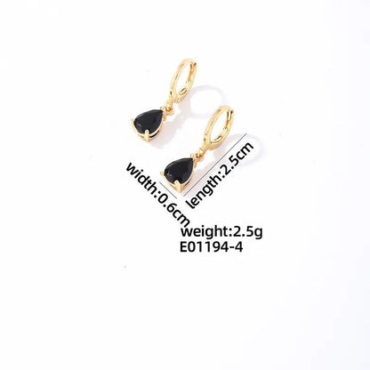 Aramat Jewels gold-tone stainless steel huggie hoop earrings featuring a dangling black teardrop zirconia stone.