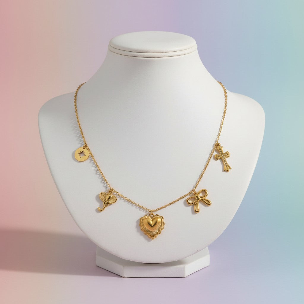 Aramat Jewels gold-tone stainless steel necklace with charms: elephant, heart, bow, cross, and star disc. Adjustable 40+5cm.