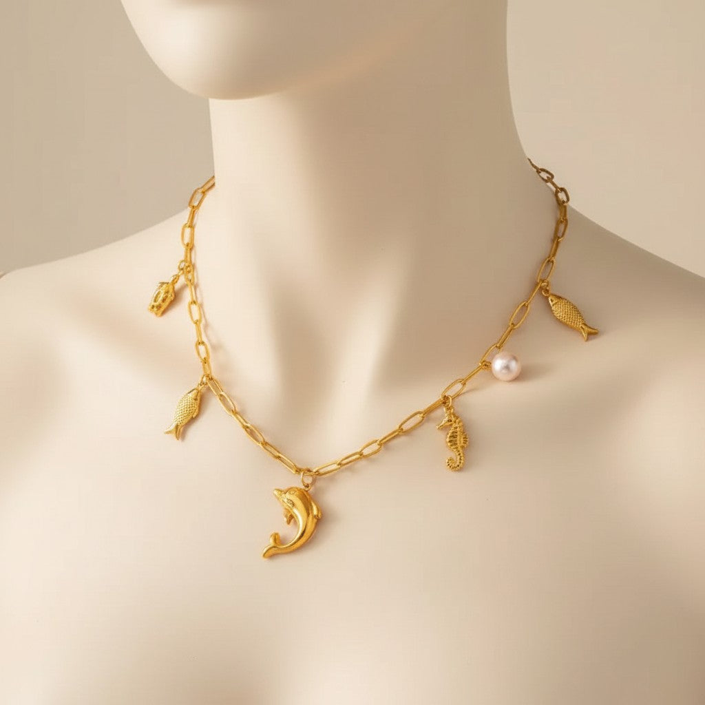 Aramat Jewels gold-tone stainless steel necklace with sea-themed charms: dolphin, turtle, fish, and a pearl. 45 cm.