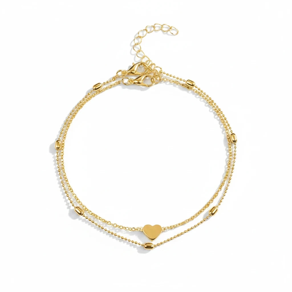 Aramat Jewels gold-tone double-layered stainless steel anklet featuring a heart charm and delicate beads.