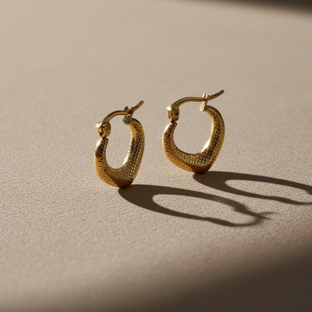 Aramat Jewels gold-colored stainless steel drop-shaped hoop earrings with a diamond pattern texture, 20x20mm.