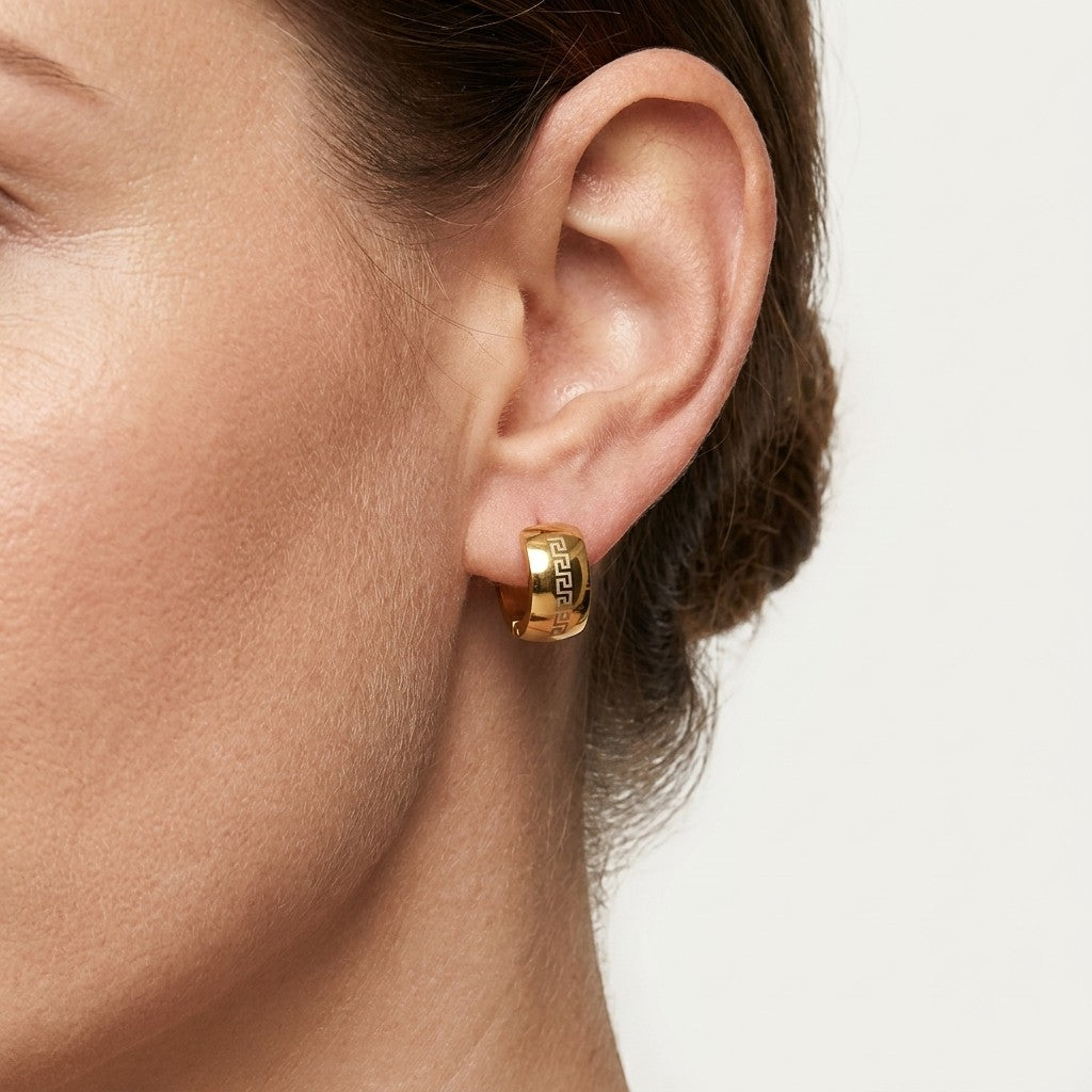 Aramat Jewels gold-tone stainless steel hoop earrings with a Greek key pattern, 13mm diameter.