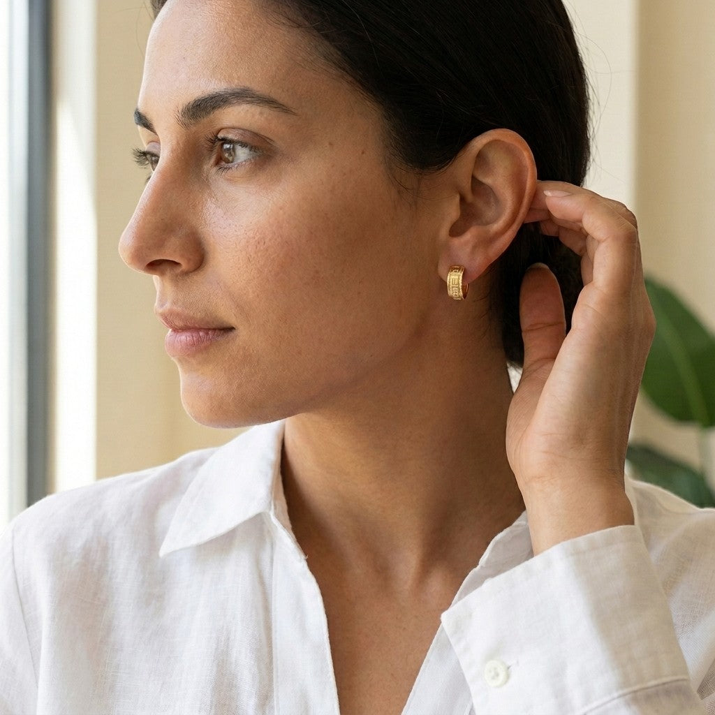 Aramat Jewels gold-tone stainless steel hoop earrings with Greek key pattern, 13mm or 20mm diameter.