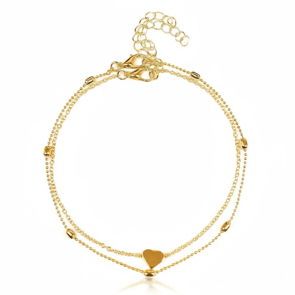 Aramat Jewels gold-colored double-layered steel anklet featuring a small heart charm and delicate beads.