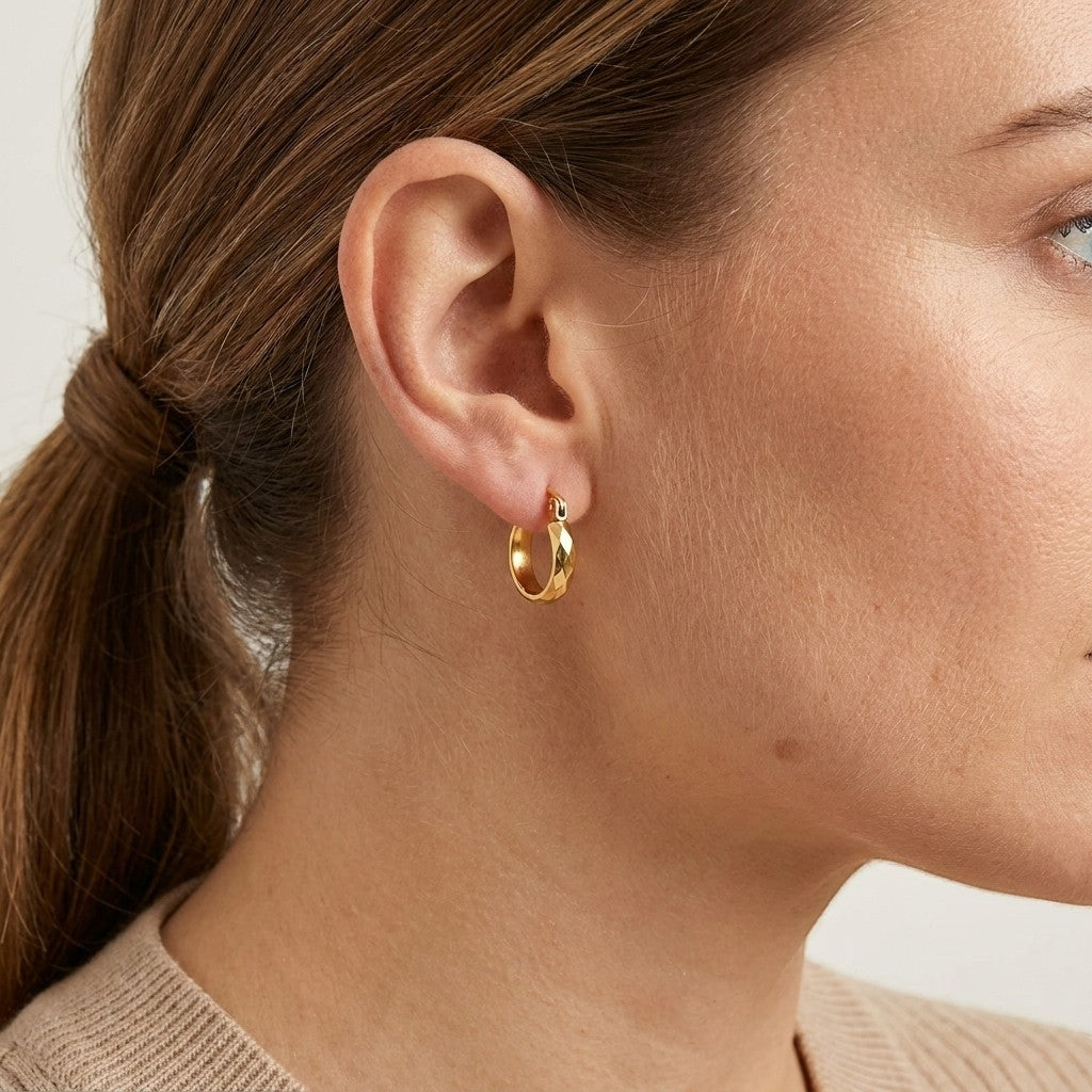 Aramat Jewels small gold-coloured stainless steel hoop earrings with flattened facets, 10mm diameter.