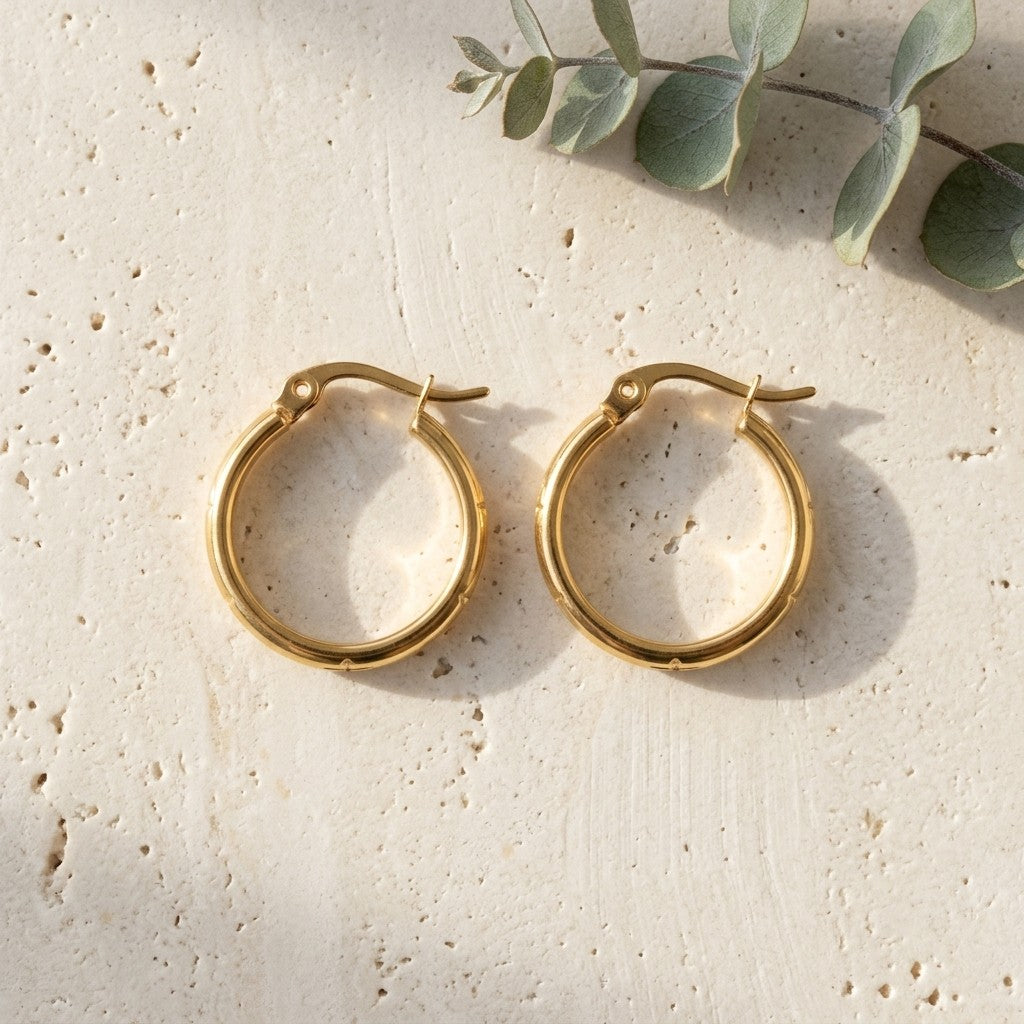 Aramat Jewels gold-tone stainless steel hoop earrings with anchor and star motif, 20mm diameter.