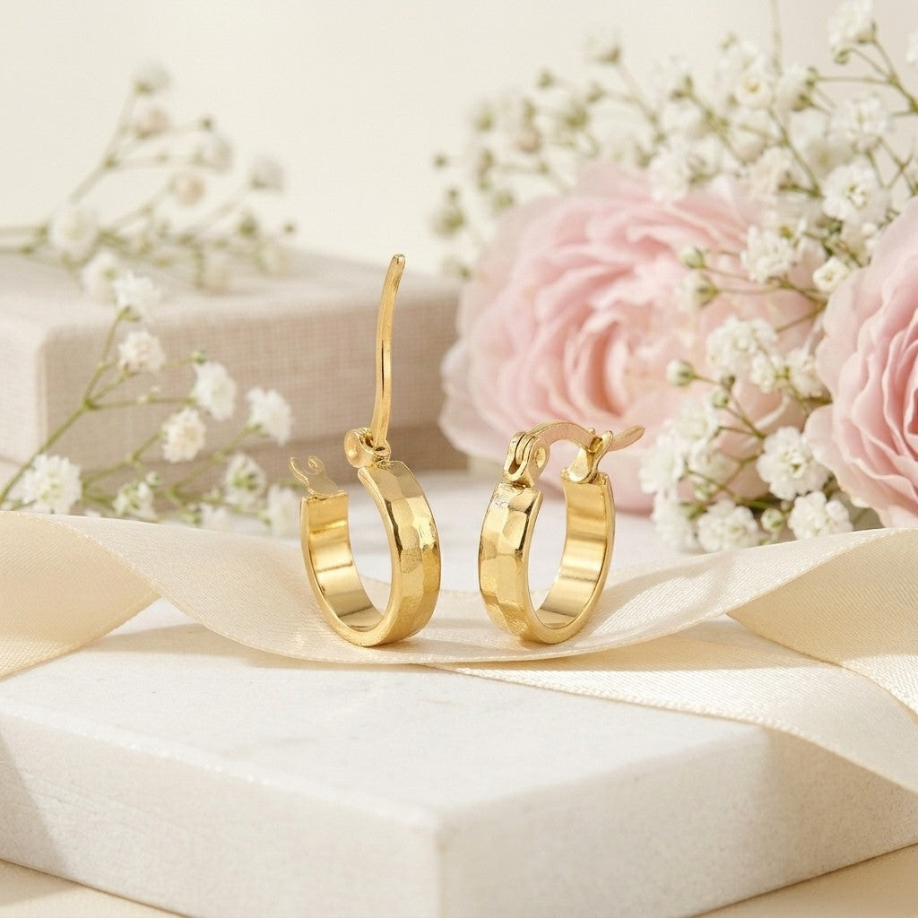 Aramat Jewels small gold-colored RVS hoop earrings with a block pattern, 10mm diameter, presented on a gift box with ribbon and flowers.