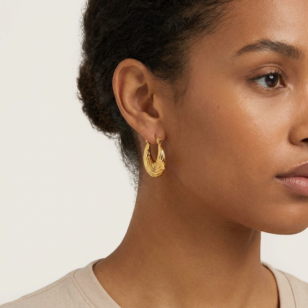 Aramat Jewels gold-tone stainless steel hoop earrings with a curved stripe design, 20mm diameter.