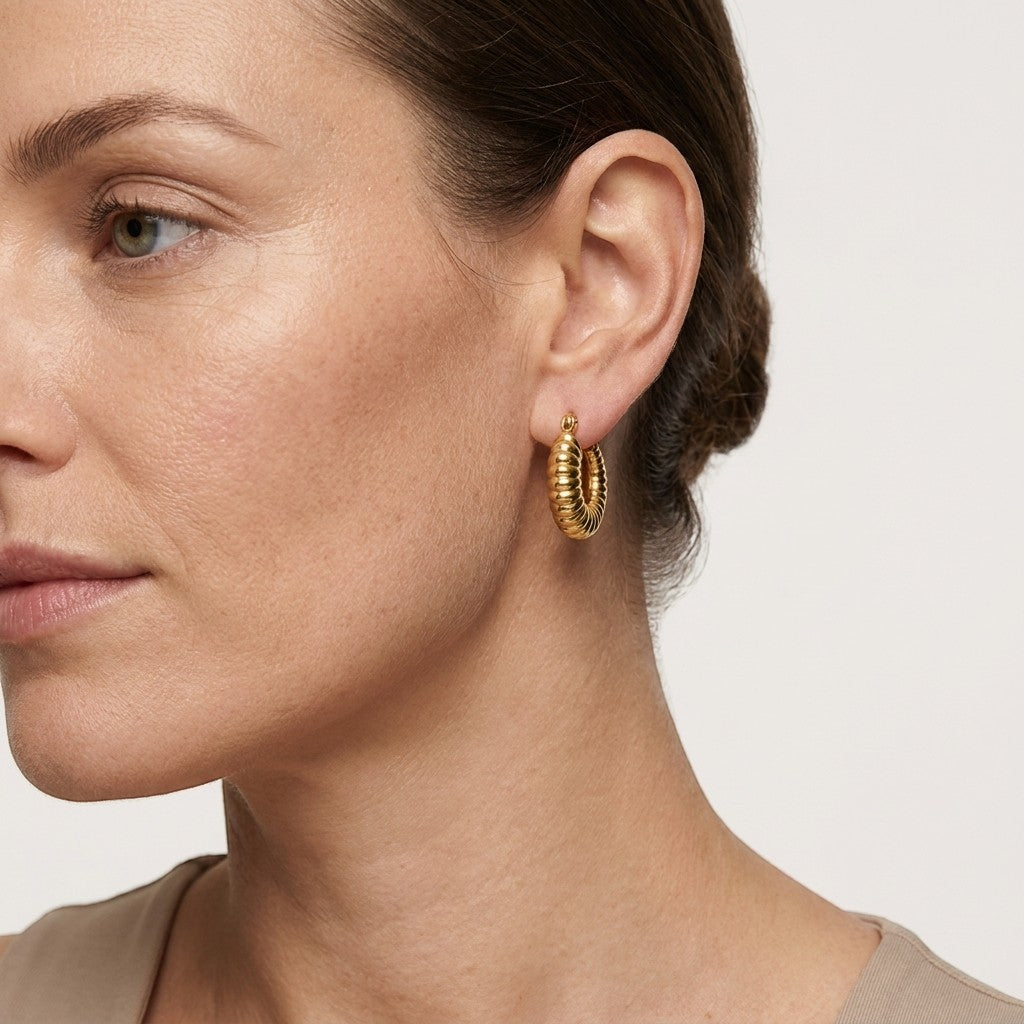 Aramat Jewels gold-coloured stainless steel hoop earrings with a ribbed texture, 20mm diameter.