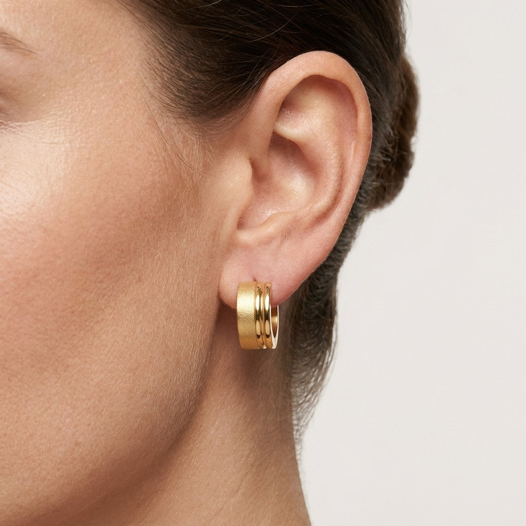 Aramat Jewels gold-tone stainless steel hoop earrings with sandblasted and shiny stripes, 13x7mm.