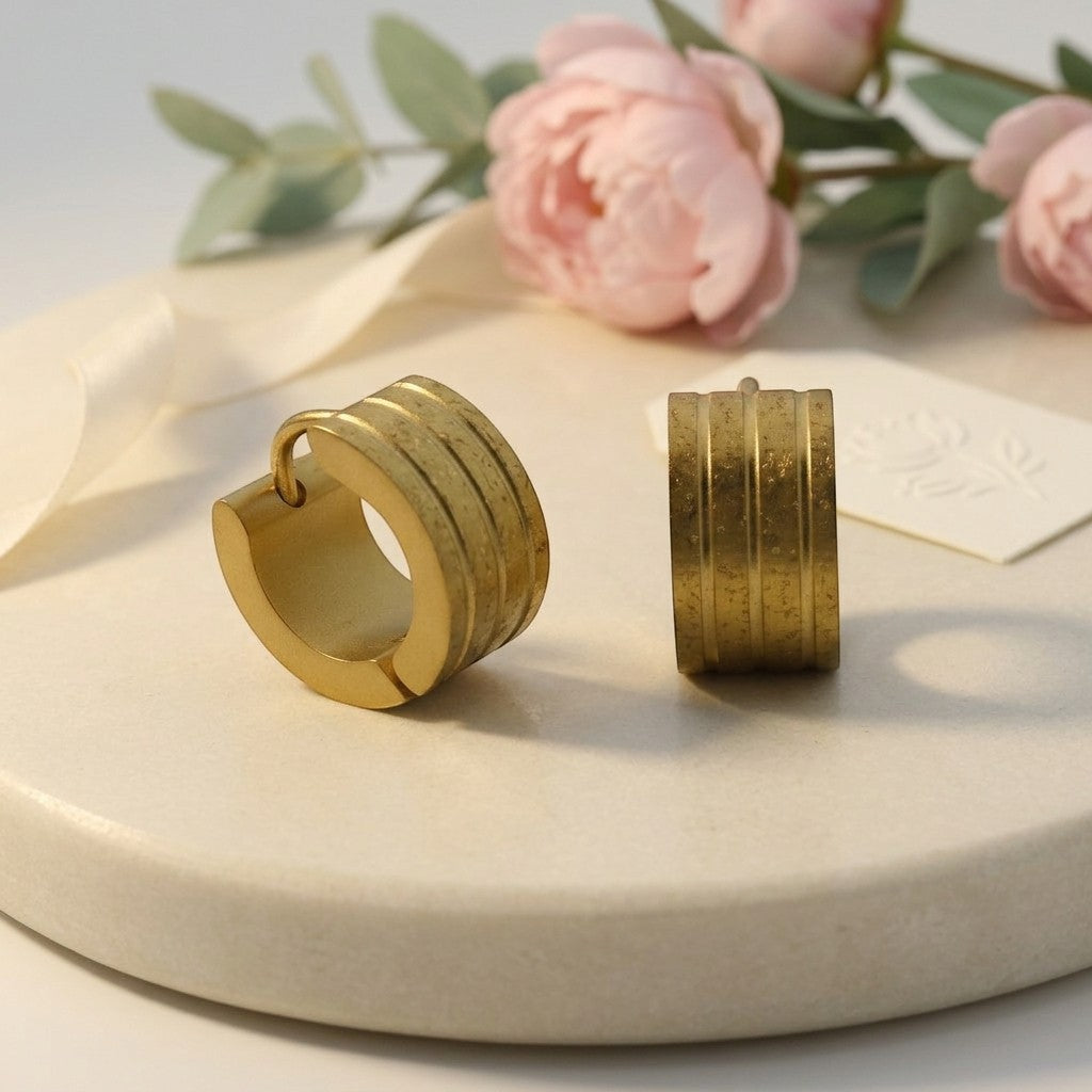 Aramat Jewels gold huggie hoop earrings with sandblasted stripes and a diamond-cut effect. Size 13mm x 7mm.