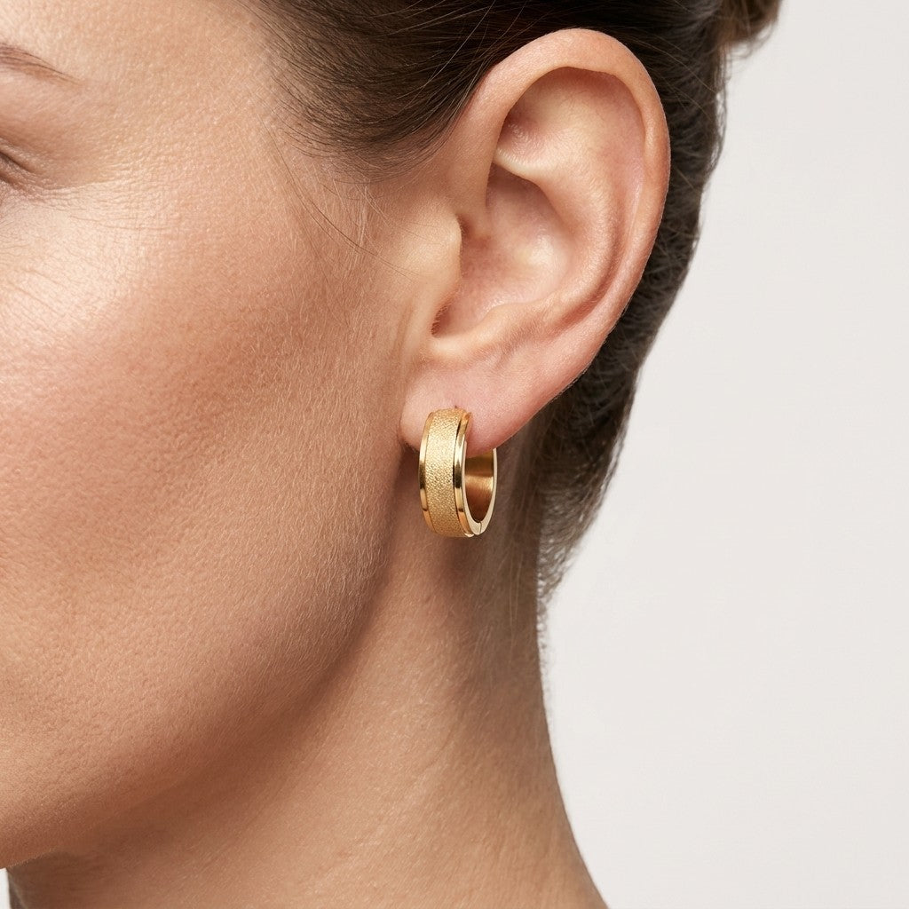 Aramat Jewels gold-tone stainless steel hoop earrings with sandblasted texture, 13mm or 20mm diameter.